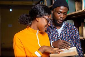 dois animado campus aluna lendo dentro a biblioteca foto