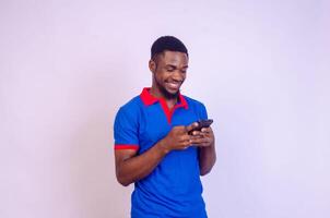 bonito jovem africano homem animado sobre o que ele Serra em dele telefone foto