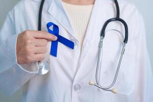 marcha colorretal Câncer consciência mês, médico com Sombrio azul fita para apoiando pessoas vivo e doença. assistência médica, esperança e mundo Câncer dia conceito foto