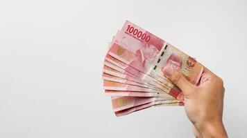 mão segurando indonésio rupia dinheiro. indonésio moeda foto
