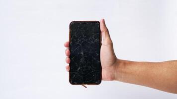 homem segurando Smartphone com quebrado tela sensível ao toque exibição em branco fundo foto