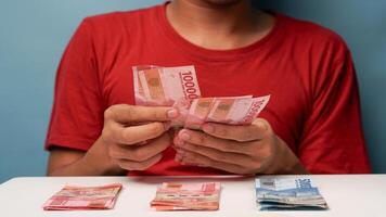 uma homem conta indonésio rupia dinheiro. financeiro gestão conceito foto