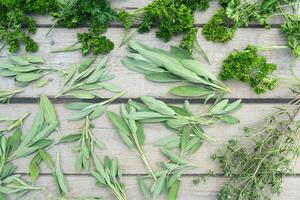 secagem fresco ervas e vegetação para especiaria Comida em de madeira escrivaninha fundo. topo Visão padronizar foto