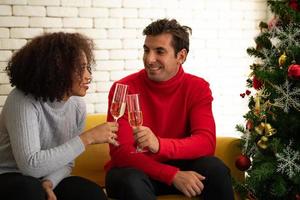 casais na sala de estar durante o feliz natal e feliz ano novo foto