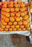 uma exibição do tomates e de outros frutas às uma mercado foto