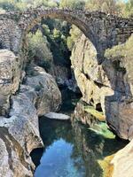 velho pedra ponte sobre uma rio dentro Peru foto