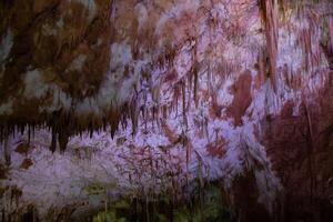 carste caverna, surpreendente Visão do estalactites e estalagnites dentro colorida brilhante luz, lindo natural ponto de referência dentro Turística lugar. foto