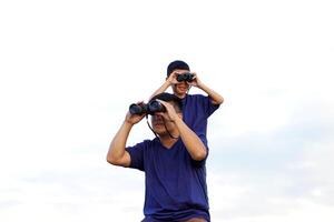 uma pai e filho usar binóculos para explorar a natureza, pássaros e animais por aí a nacional parque enquanto acampamento com a família. a conceito do ao ar livre Atividades, natureza Educação, explorando natureza. foto