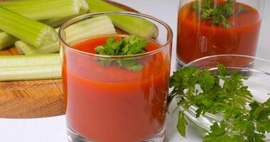 óculos do tomate suco em uma branco mesa. saudável e vegetariano Comida conceito foto