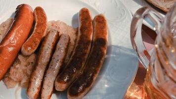 assado tradicional Comida. defumado salsichas carne suspensão dentro doméstico fumeiro.salsichas em branco prato foto