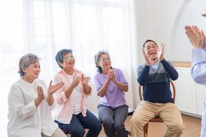 Senior fêmeas e masculino sentado em banco. Mais velho pessoas estão ouvindo e apreciar encontro foco grupo às vivo sala. alegre despreocupado aposentado Senior amigos desfrutando relaxamento às aproximadamente lar. foto