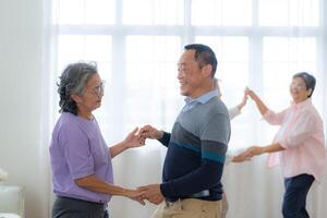 ásia Mais velho masculino e fêmeas pessoas dança com seus parceiros em uma dançando chão dentro vivo espaço. feliz Mais velho casal realizando pegue exercício. alegre despreocupado aposentado Senior amigos desfrutando relaxamento foto