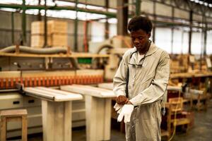 africano homem trabalhadores Engenharia em pé com confiança com trabalhando suíte vestir e mão luva dentro frente máquina. conceito do inteligente indústria trabalhador operativo. madeira fábrica produzir madeira palato. foto