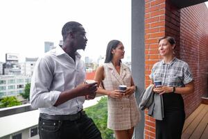 equipe do o negócio pessoas inteligente homem e mulheres ficar de pé às ao ar livre terraço construção e conversa juntos com café da manhã Comida e café em a mão dentro Boa sentindo-me com cidade espaço prédio. o negócio manhã. foto