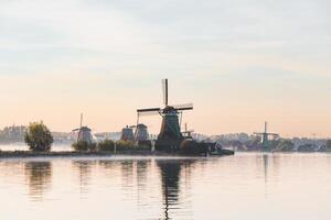 popular turista local Zaanse Schans é perto amsterdam dentro a oeste do a Holanda. histórico, realista moinhos de vento durante nascer do sol. Holanda ponto de referência foto