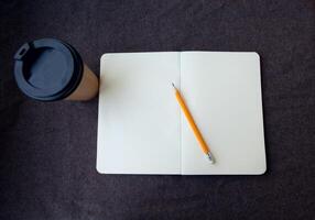 lápis, caderno e papel café copo foto