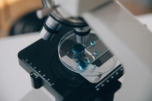 equipe de cientistas de pesquisa bioquímica trabalhando com microscópio para desenvolvimento de vacina contra coronavírus em laboratório de pesquisa farmacêutica, foco seletivo foto