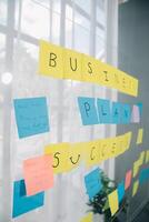 jovem criativo equipe profissional usando postar isto notas dentro vidro parede para escrevendo estratégia o negócio plano para desenvolvimento crescer para sucesso. foto