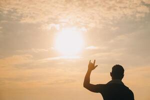 mão coração quadro, Armação forma silhueta fez contra a Sol céu do uma nascer do sol ou pôr do sol em uma montanha. foto