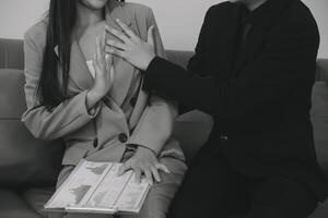 sexual assédio dentro ambiente de trabalho. infeliz fêmea empregado olhando às mão do patrão toque às dela ombro e sentindo-me com nojo. foto