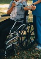 jovem enfermeira ou fisioterapeuta dentro esfrega ajudando uma feliz aposentado velho mulher Faz ginástica exercícios com luz peso halteres às lar. conceito do fisioterapia para idosos foto