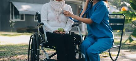 enfermeira com idosos homem dentro cadeira de rodas às parque foto