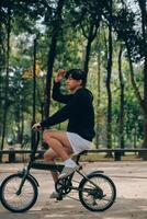 bonito feliz jovem homem com bicicleta em uma cidade rua, ativo estilo de vida, pessoas conceito foto