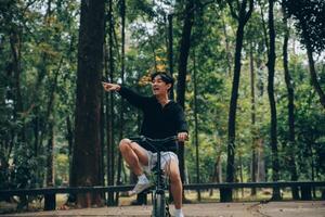 bonito feliz jovem homem com bicicleta em uma cidade rua, ativo estilo de vida, pessoas conceito foto