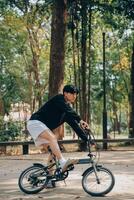 bonito feliz jovem homem com bicicleta em uma cidade rua, ativo estilo de vida, pessoas conceito foto