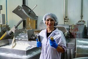 caucasion mulher trabalhando dentro uma Comida fábrica vestindo protetora roupas e luvas. foto