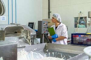 caucasion mulher trabalhando dentro uma Comida fábrica vestindo protetora roupas e luvas. foto