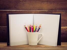cor lápis e caderno de desenho em de madeira fundo foto