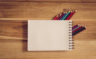 cor lápis e caderno de desenho em madeira mesa foto