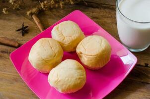 pão travessas e leite dentro vidro em de madeira chão. foto