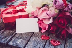 vermelho presente caixas, vermelho corações e rosas estão colocada em uma de madeira chão.e bênção cartão - conceito para amor foto