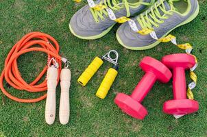 ginástica conceito com exercício equipamento em verde Relva fundo. foto