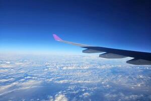 fechar acima avião asa com lindo azul céu fundo. foto