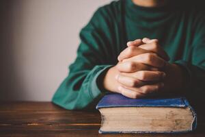 mãos mulher deitado em a bíblico enquanto Rezar para cristão religião bênçãos e orar para Deus foto