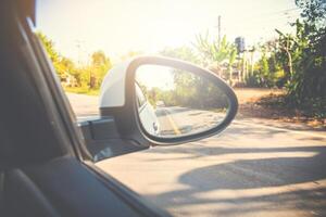 visão traseira espelho carro dentro a reflexão floresta e grandes estrada foto