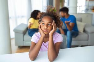 frustrado pequeno menina sentindo-me depressivo enquanto Bravo pais brigando às lar. preocupado chateado pequeno filha doeu de pais e mães pausa acima ou divórcio. foto