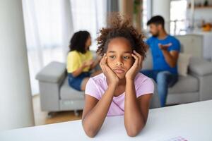 frustrado pequeno menina sentindo-me depressivo enquanto Bravo pais brigando às lar. preocupado chateado pequeno filha doeu de pais e mães pausa acima ou divórcio. foto