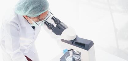 fêmea médico investigador olhando às uma microscópio dentro uma médico laboratório. médico experimental conceito foto