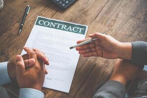 homem de negocios é negociando, avisando, e explicando a importam do a contrato para estar acordado para placa a contrato. foto