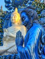 Rezar monge estátua às wat rong suéa dez azul têmpora, Chiang Rai, Tailândia foto