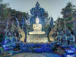 Rezar monges e Buda estátuas às wat rong suéa dez azul têmpora, Chiang Rai, Tailândia foto