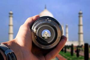 seletivo foco tiro pessoa segurando Câmera lente em taj mahal turista levando uma cenário com Câmera lente em taj mahal foto