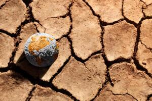 água crise, clima mudar, el nino, global aquecimento questão conceito. Castanho globo deitar em rachado seco solo chão. terra sem água. Alto temperatura em quente ensolarado dia foto