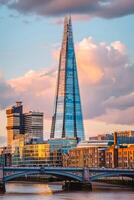 ai gerado a fragmento renomado arranha-céu dentro Londres, em pé alta contra parcialmente nublado céu. a fragmento é construído com vidro painéis este refletir a em torno da ambiente. ai gerado foto