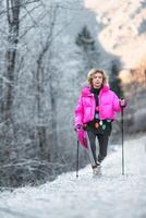 mulher práticas nórdico caminhando dentro a neve foto
