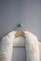 branco pele casaco suspensão em uma cabide dentro uma guarda roupa sala. foto